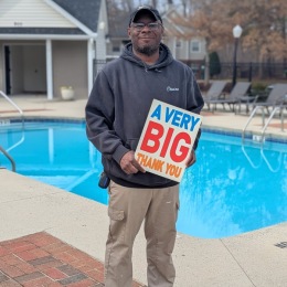 a man holding a sign by a pool