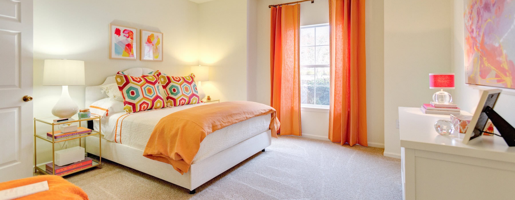 Large well lit bedroom with carpets and a large window